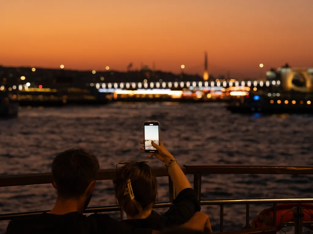 İstanbul'da gün batımında Boğaz'ı telefonla çeken çift
