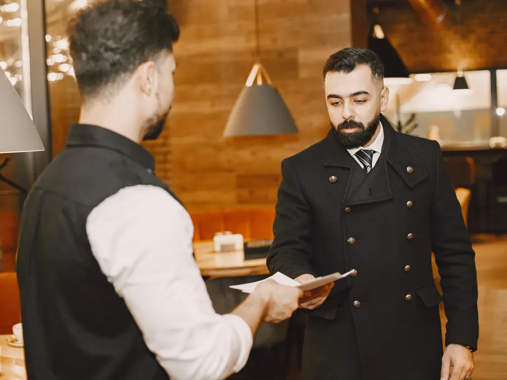 Restoranda müşteriye menü uzatan garson