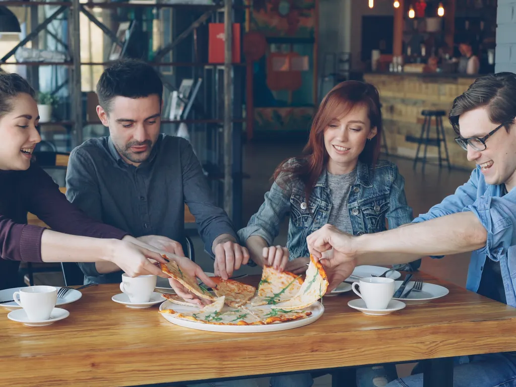 Kafede pizza paylaşan bir grup arkadaş